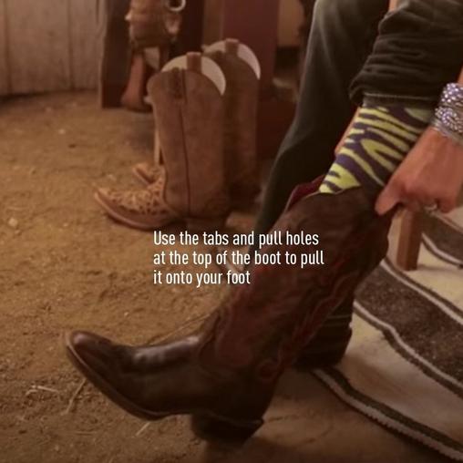 woman pulling on cowboy boots